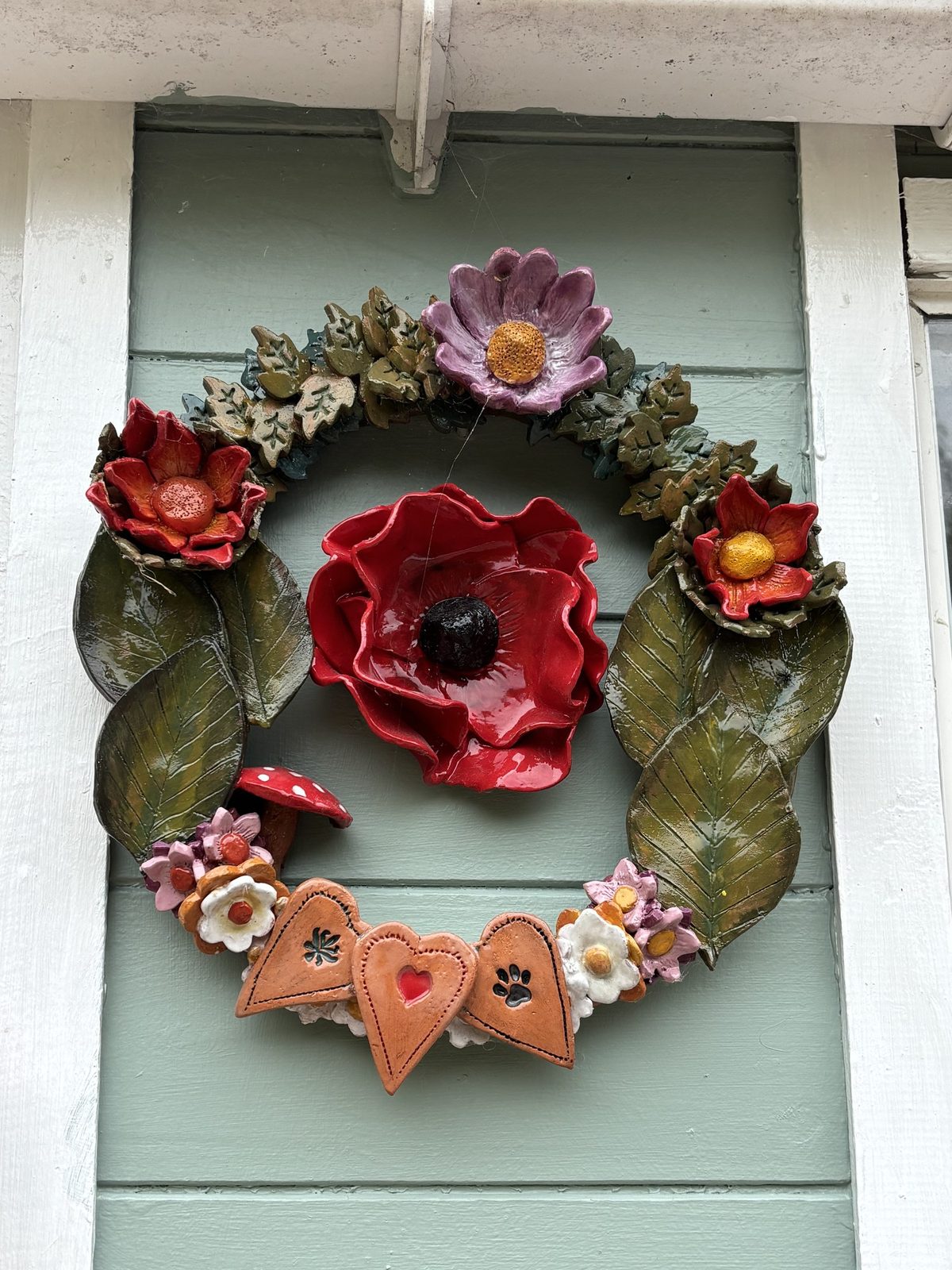 Clay flower wreath with a red poppy