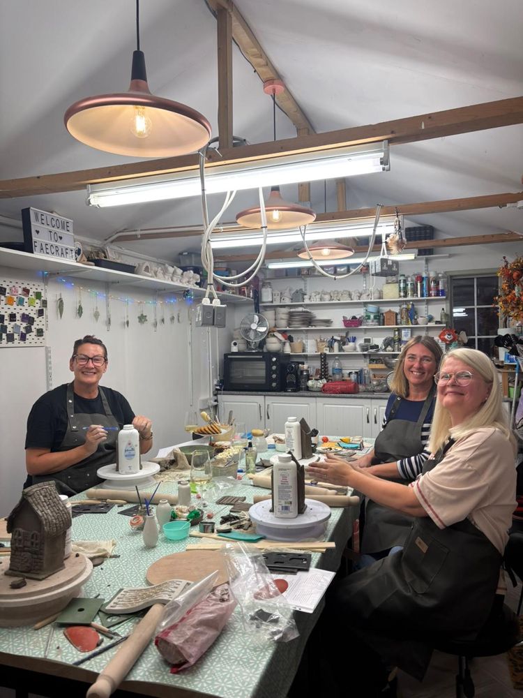 A Clay Club group round the big table at The Atelier, smiling at the camera