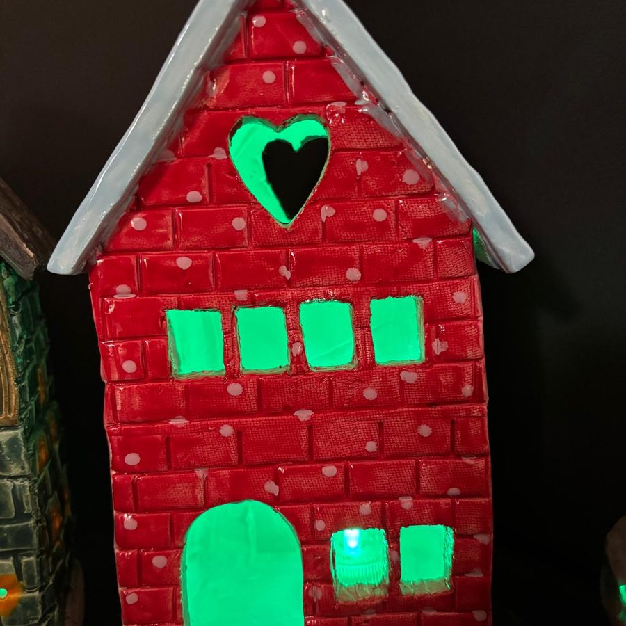 Red clay house lit from inside with green windows