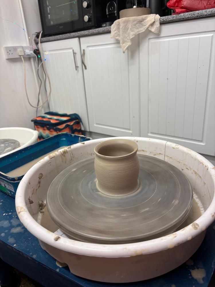 A freshly thrown pot on the wheel