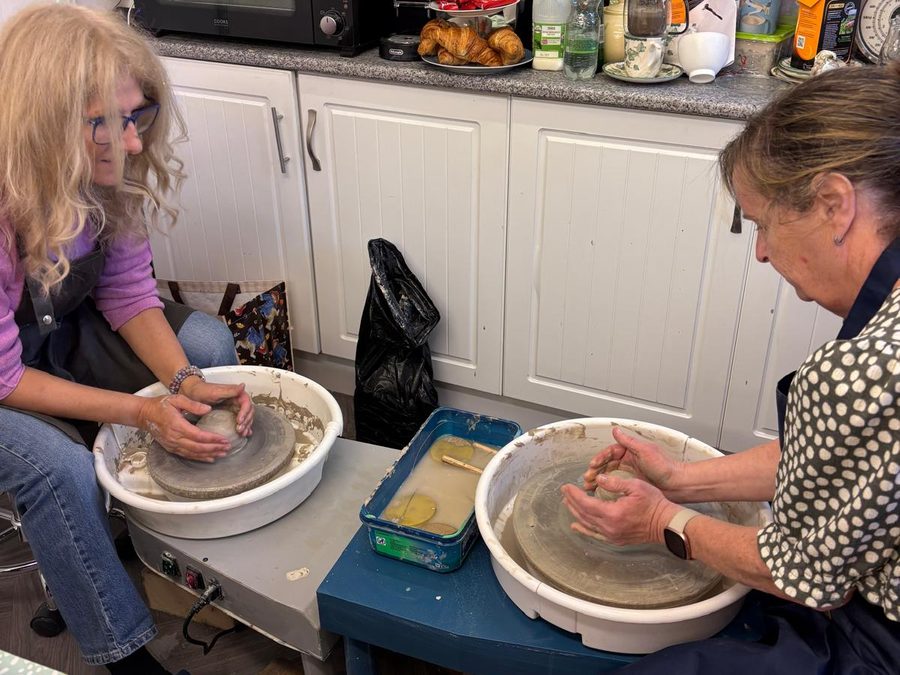 Two makers throwing at the pottery wheels