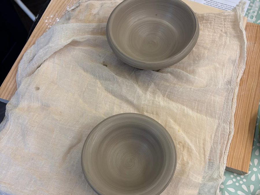 Two freshly thrown clay bowls set aside on cloth