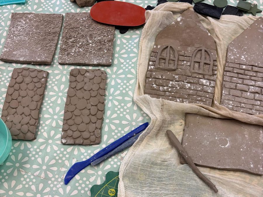 Clay house walls with brick, pebble and floral textures and arched windows